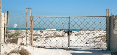 A steel gate protecting a beach property